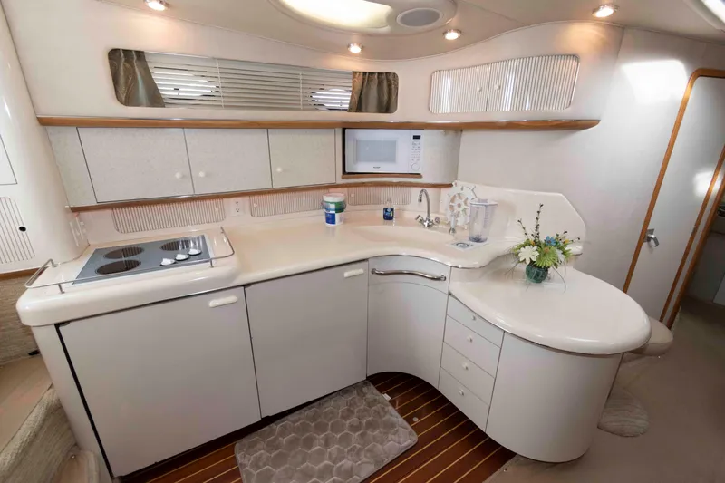 Slide: The Image of Luxurious 1995 Sea Ray 440 Sundancer yacht kitchen with modern amenities and elegant design. - 9