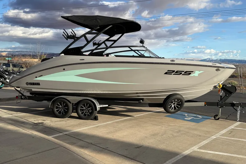 Slide: The Image of 2026 Yamaha Boats 255XD on trailer, parked outdoors under cloudy sky. - 6