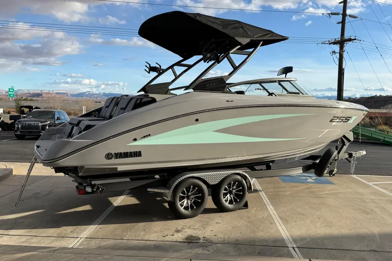 Slide: The Image of 2026 Yamaha Boats 255XD on trailer, sleek design, parked outdoors under a blue sky. - 7