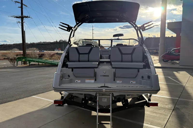 Slide: The Image of 2026 Yamaha Boats 255XD, rear view, parked outdoors under a sunny sky. - 9