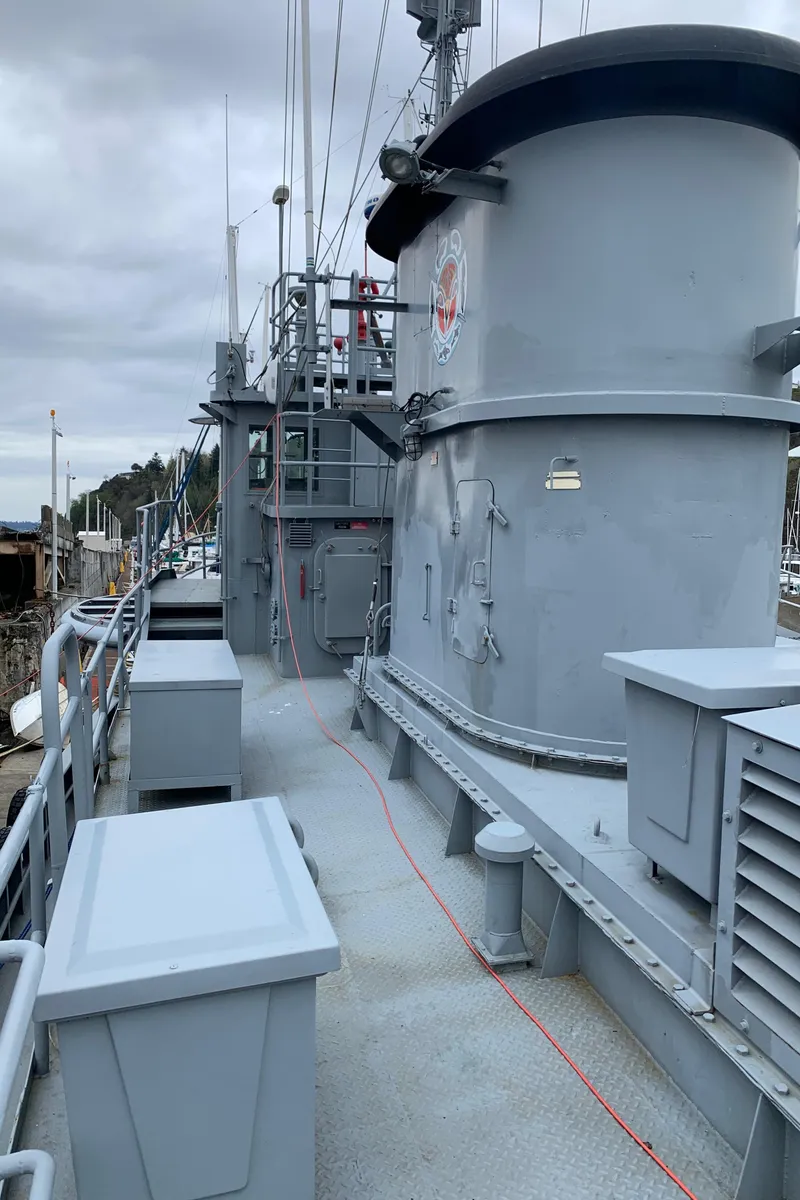 Slide: The Image of 1955 L-T 100 Steel Army Tugboat deck with industrial design and overcast sky. - 10