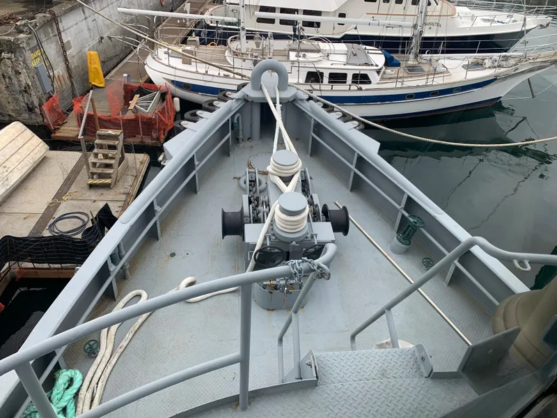 Slide: The Image of 1955 L-T 100 Steel Army Tugboat docked, showing deck and mooring equipment. - 13