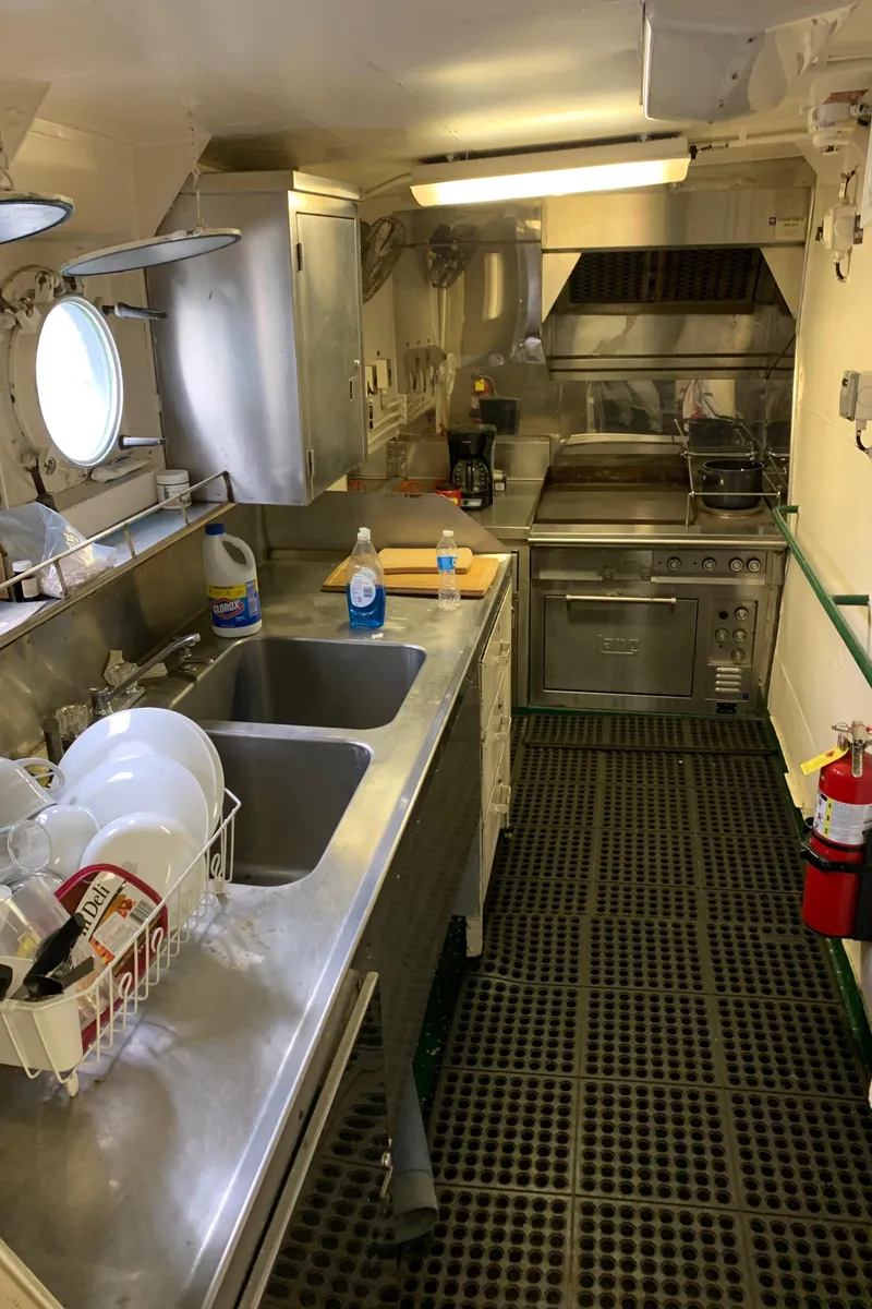 Slide: The Image of 1955 Tugboat L-T 100 Steel Army Tug kitchen with stainless steel appliances and safety equipment. - 14