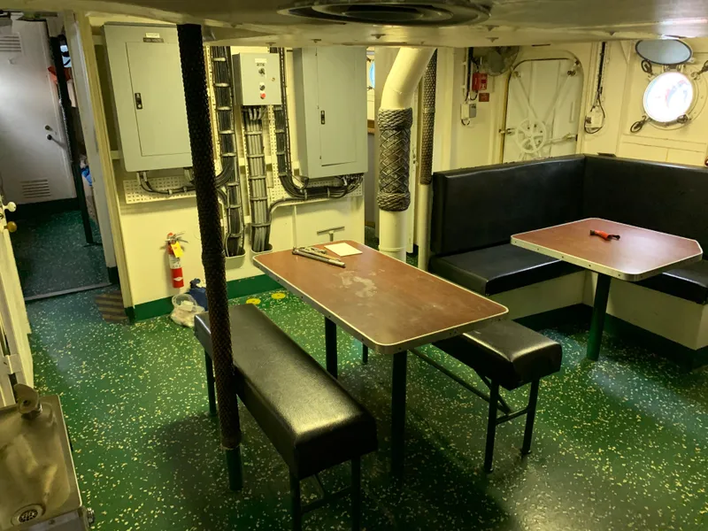 Slide: The Image of 1955 Tugboat L-T 100 Steel Army Tug interior with green flooring and dining area. - 16
