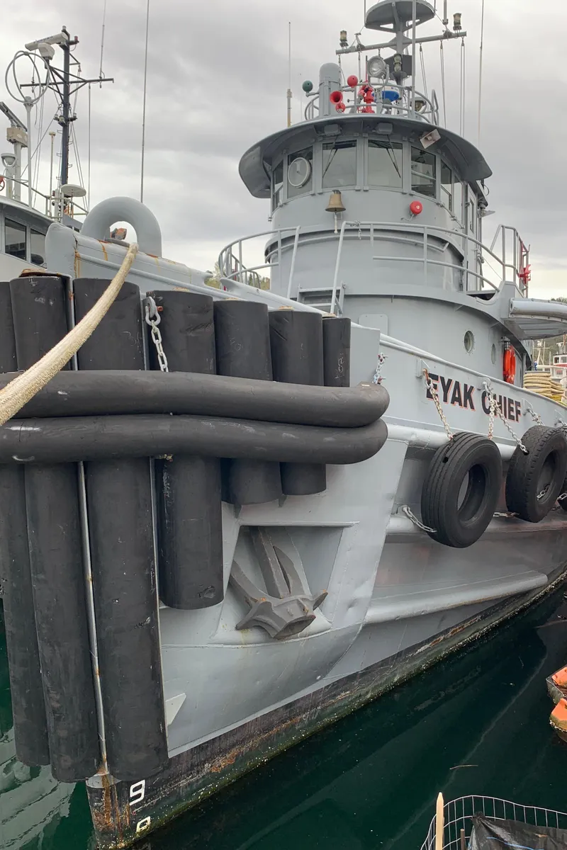 Slide: The Image of 1955 L-T 100 Steel Army Tugboat docked, featuring robust design and fendering. - 2