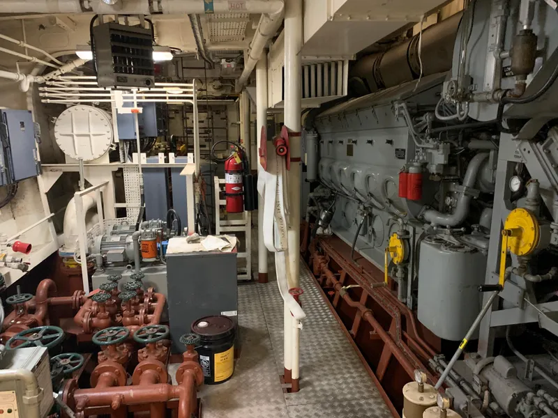 Slide: The Image of Engine room of 1955 Tugboat L-T 100 Steel Army Tug, featuring machinery and control systems. - 24
