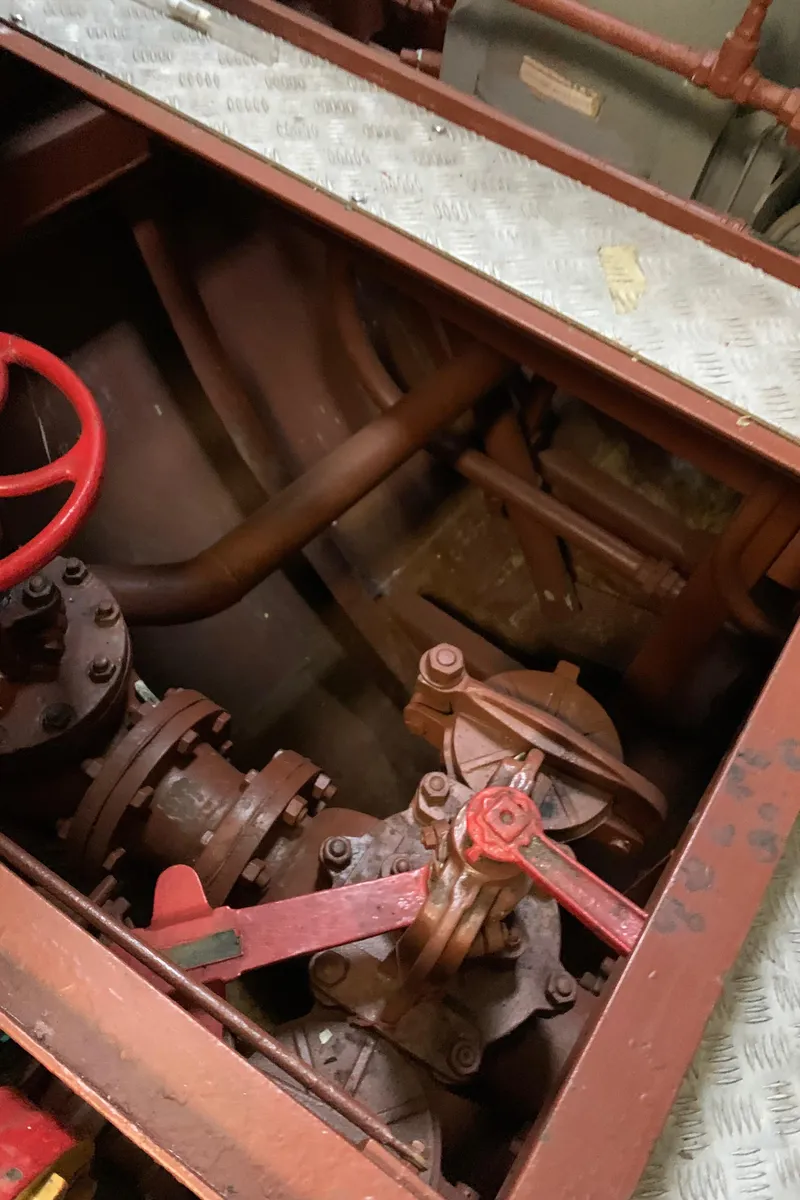 Slide: The Image of Engine room of 1955 Tugboat L-T 100 Steel Army, featuring red valve and machinery. - 34