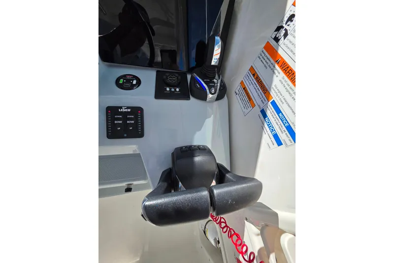 Slide: The Image of 2024 Pursuit OS 325 Offshore boat interior at marina, showcasing seating and helm. - 14