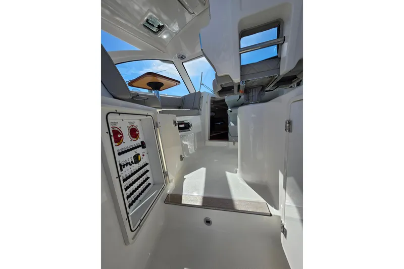 Slide: The Image of 2024 Pursuit OS 325 Offshore boat interior at marina, showcasing seating and helm. - 15