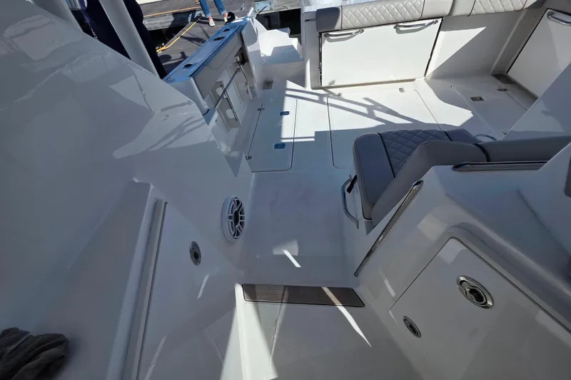 Slide: The Image of 2024 Pursuit OS 325 Offshore boat docked in a marina under clear blue skies. - 16