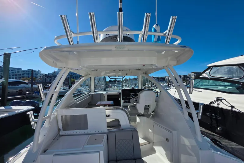 Slide: The Image of 2024 Pursuit OS 325 Offshore yacht docked in a marina under clear blue skies. - 22