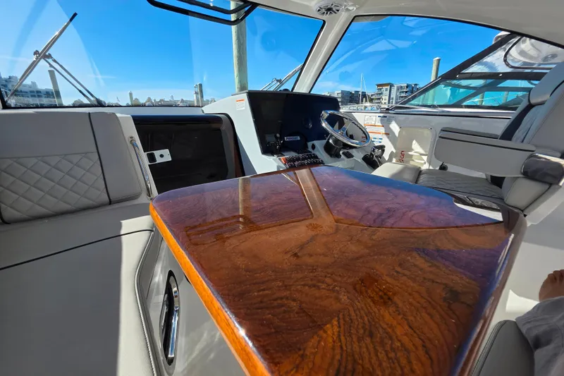 Slide: The Image of 2024 Pursuit OS 325 Offshore boat docked in marina, open hatch, calm water reflections. - 23