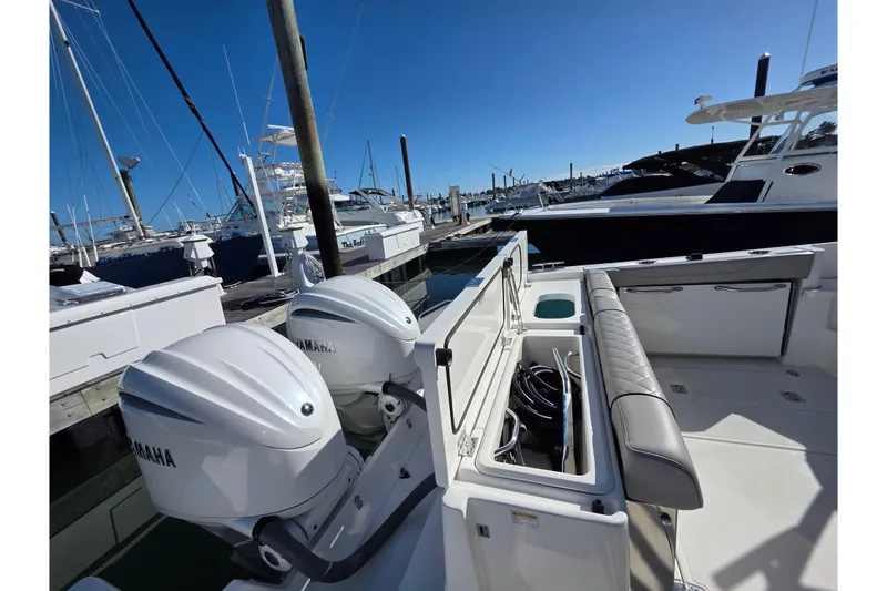 Slide: The Image of 2024 Pursuit OS 325 Offshore boat docked with twin Yamaha engines. - 26