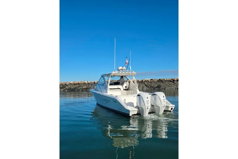 Slide: The Image of 2024 Pursuit OS 325 Offshore boat on calm water, clear sky background. - 3