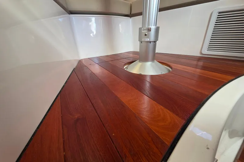 Slide: The Image of 2024 Pursuit OS 325 Offshore boat interior at marina, featuring helm and seating area. - 34