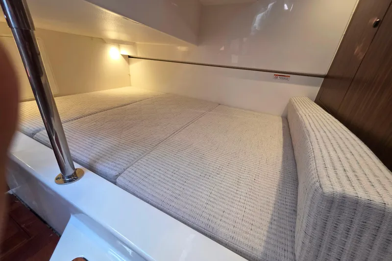 Slide: The Image of 2024 Pursuit OS 325 Offshore boat interior with seating and helm, docked at marina. - 38