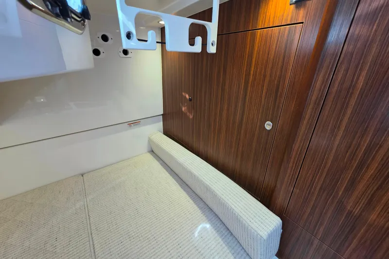 Slide: The Image of 2024 Pursuit OS 325 Offshore boat interior with polished wood table and modern helm. - 39
