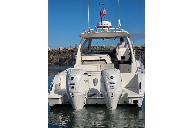 Slide: The Image of 2024 Pursuit OS 325 Offshore boat on calm water, clear sky background. - 4