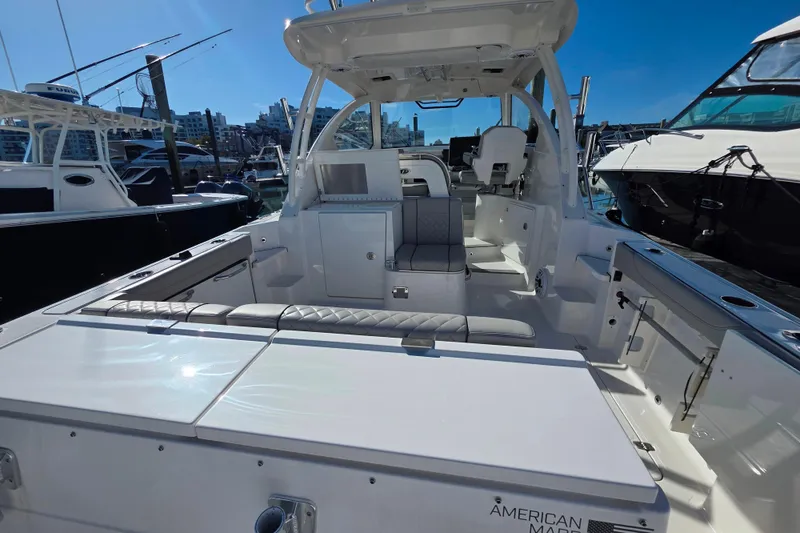 Slide: The Image of 2024 Pursuit OS 325 Offshore boat interior with helm and seating at marina. - 40