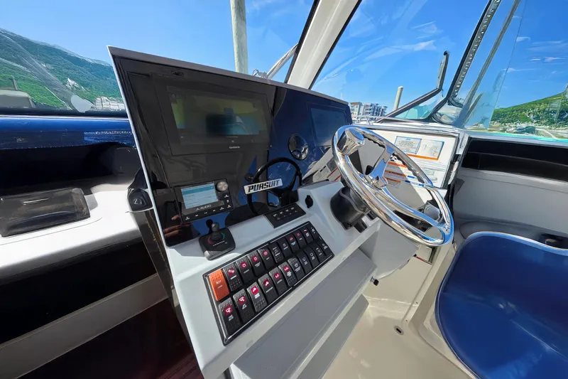Slide: The Image of 2024 Pursuit OS 325 Offshore helm with modern controls and navigation system. - 42