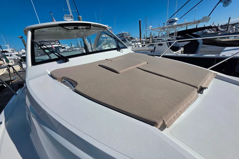 Slide: The Image of 2024 Pursuit OS 325 Offshore boat controls and dashboard with warning labels. - 49