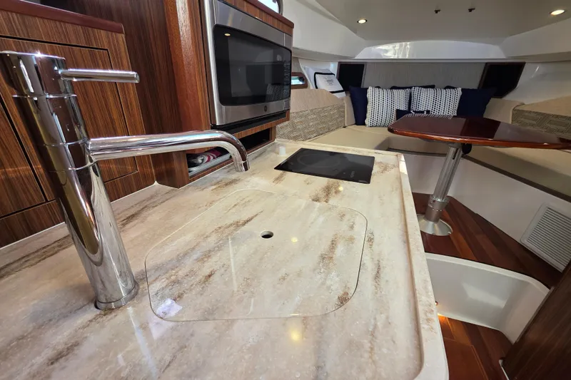 Slide: The Image of 2024 Pursuit OS 325 Offshore interior with modern kitchen and cozy seating area. - 54