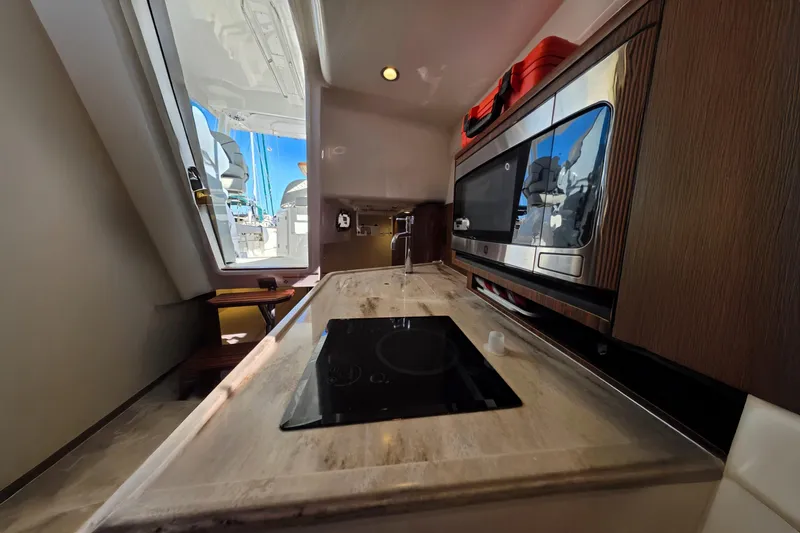 Slide: The Image of 2024 Pursuit OS 325 Offshore yacht kitchen with modern appliances and sleek design. - 55