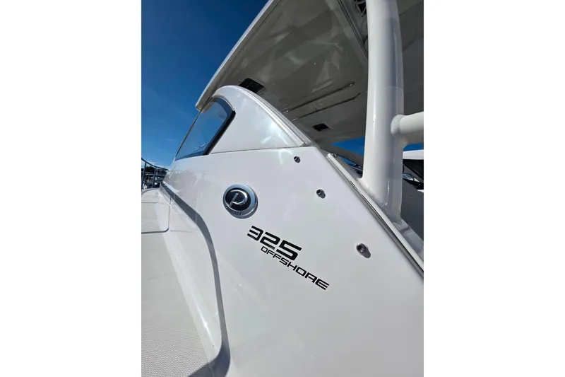 Slide: The Image of 2024 Pursuit OS 325 Offshore boat with dual Yamaha 300 V6 engines on calm water. - 6