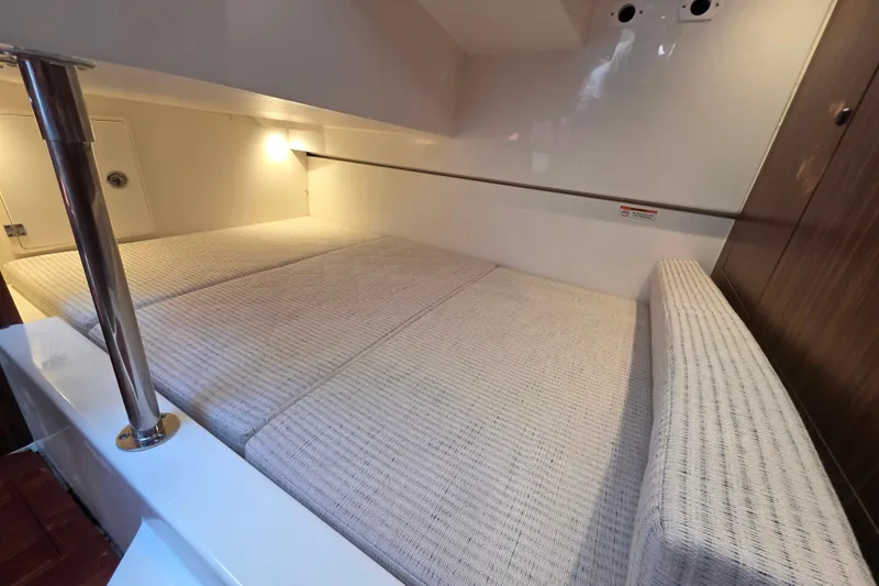 Slide: The Image of 2024 Pursuit OS 325 Offshore cabin interior with cozy bedding and ambient lighting. - 61
