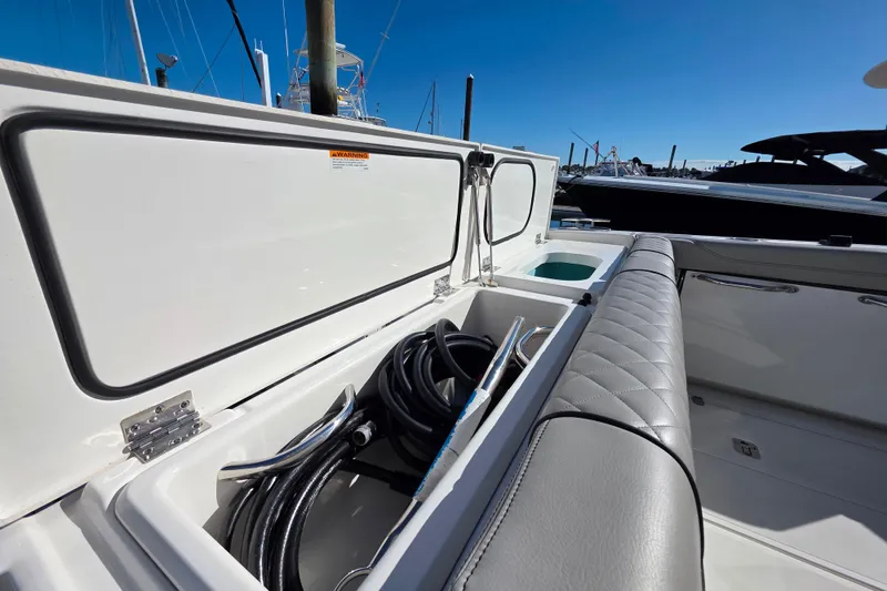 Slide: The Image of 2024 Pursuit OS 325 Offshore boat docked among other vessels under clear blue sky. - 8