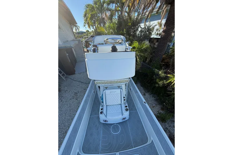 Slide: The Image of 2016 Yellowfin 24 Bay boat with sleek deck design and palm trees in the background. - 10