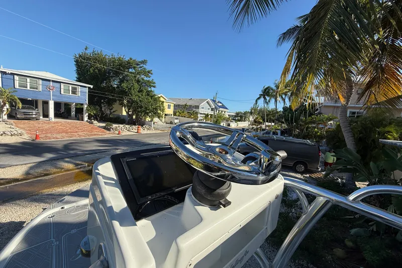 Slide: The Image of 2016 Yellowfin 24 Bay boat steering wheel with a tropical neighborhood backdrop. - 12