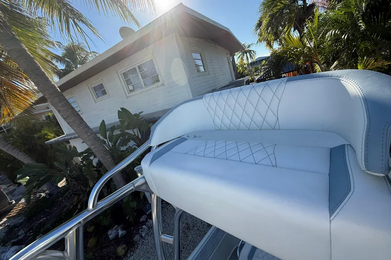 Slide: The Image of 2016 Yellowfin 24 Bay boat seat with tropical house and palm trees in background. - 13