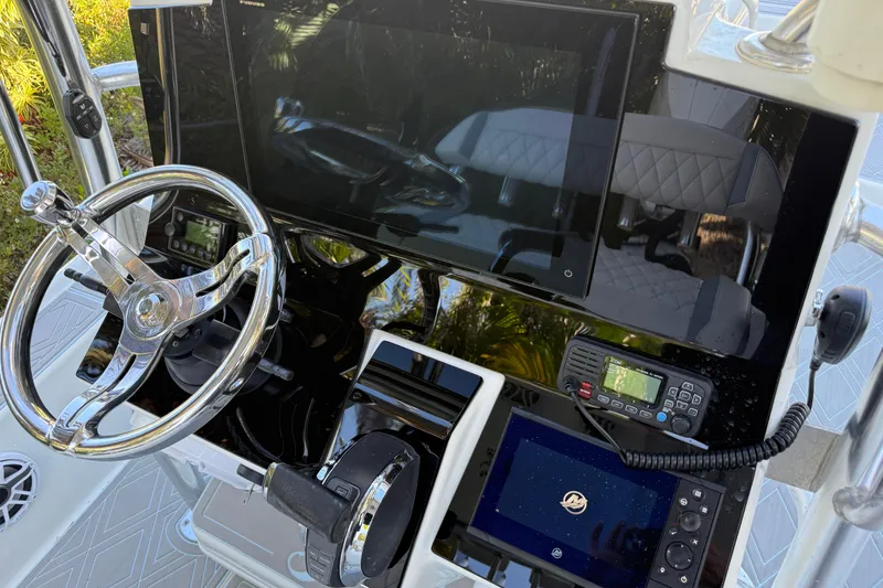 Slide: The Image of 2016 Yellowfin 24 Bay boat dashboard with steering wheel and electronic controls. - 14