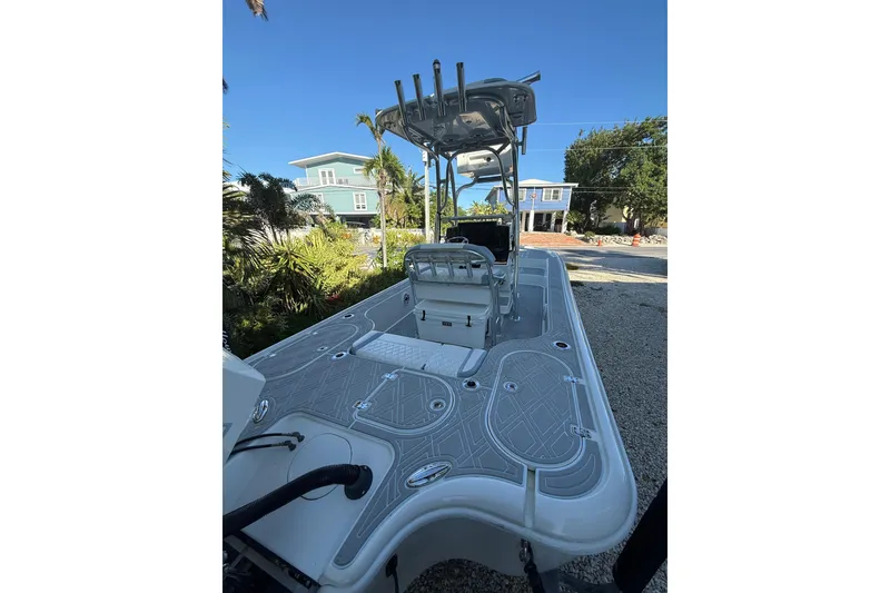 Slide: The Image of 2016 Yellowfin 24 Bay boat with sleek deck design, parked outdoors under clear blue sky. - 4