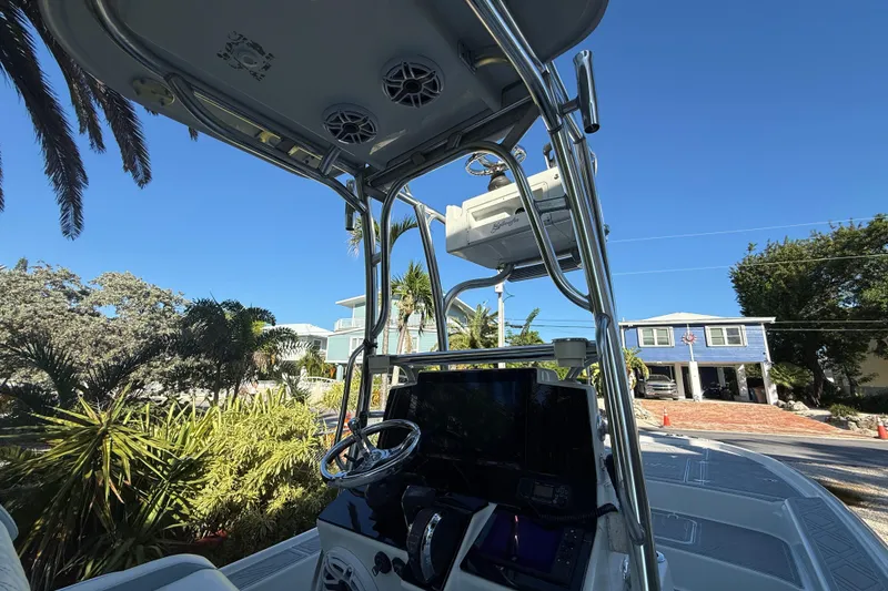 Slide: The Image of 2016 Yellowfin 24 Bay boat with console and steering wheel, surrounded by tropical scenery. - 7
