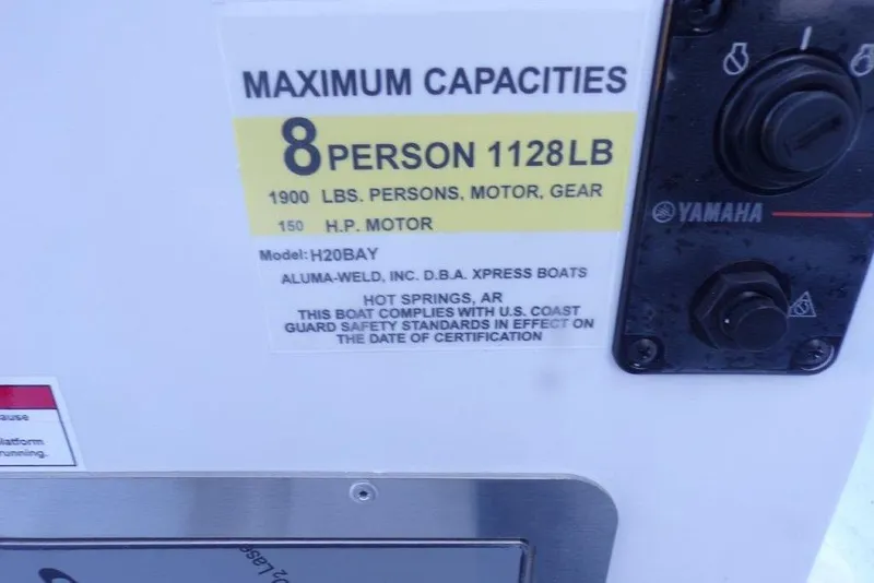 Slide: The Image of 2026 Xpress H20B Bay boat capacity label, 8 persons, 1128 lbs, 150 HP motor. - 5
