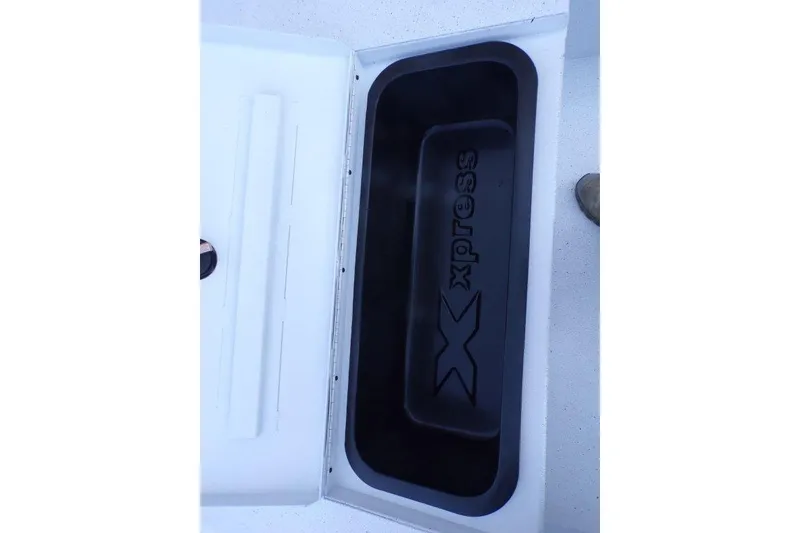 Slide: The Image of 2026 Xpress H20B Bay boat storage compartment with logo, open lid view. - 8