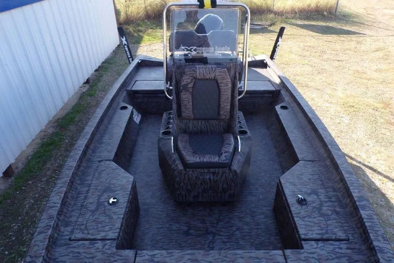 Slide: The Image of 2026 Xpress H20B Bay boat interior with camouflage seating and storage compartments. - 2