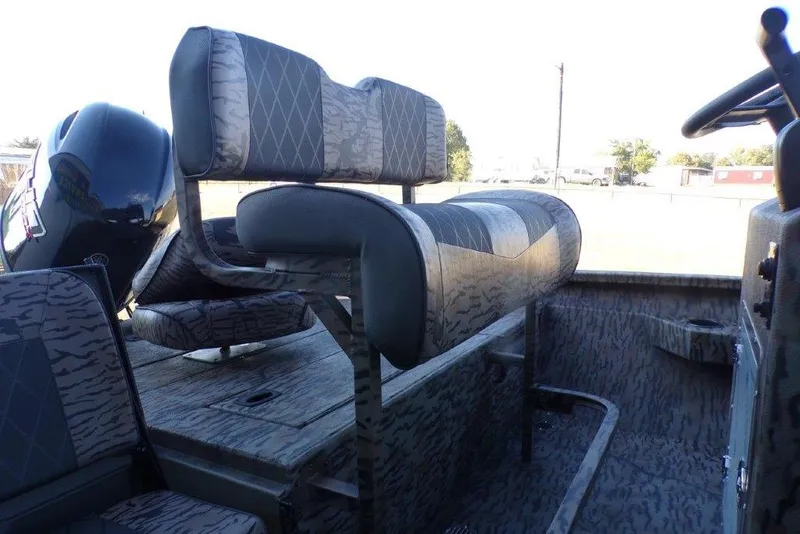 Slide: The Image of 2026 Xpress H20B Bay boat interior with camo seating and steering console. - 4