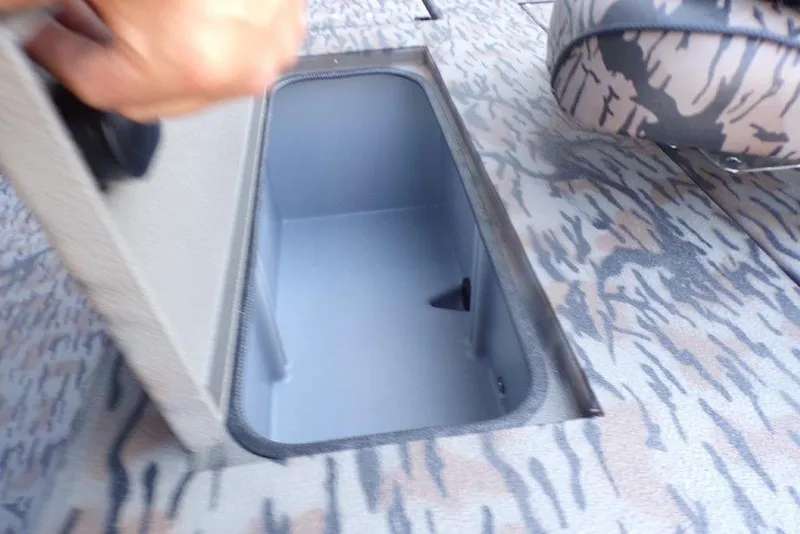 Slide: The Image of Open storage compartment on 2026 Xpress H20B Bay boat with camo pattern interior. - 5