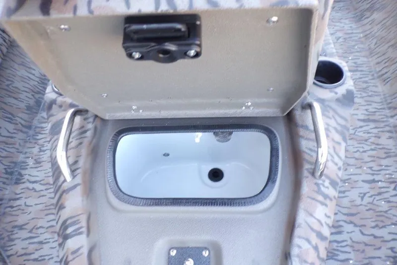 Slide: The Image of Open storage compartment in 2026 Xpress H20B Bay boat with camouflage interior. - 8