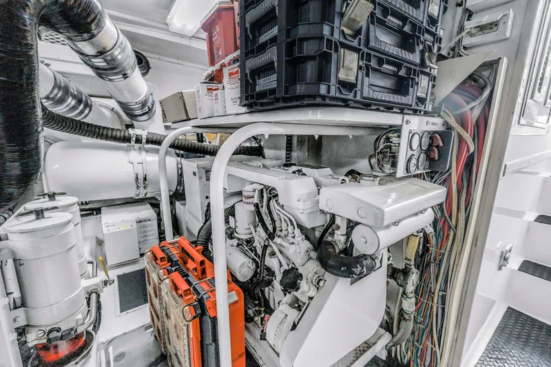 Slide: The Image of Engine room of 1999 Viking 72 Enclosed Bridge yacht, featuring mechanical components and storage. - 101
