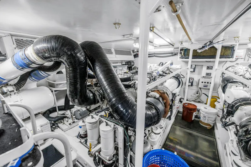 Slide: The Image of Engine room of 1999 Viking 72 Enclosed Bridge yacht, featuring complex machinery and equipment. - 103