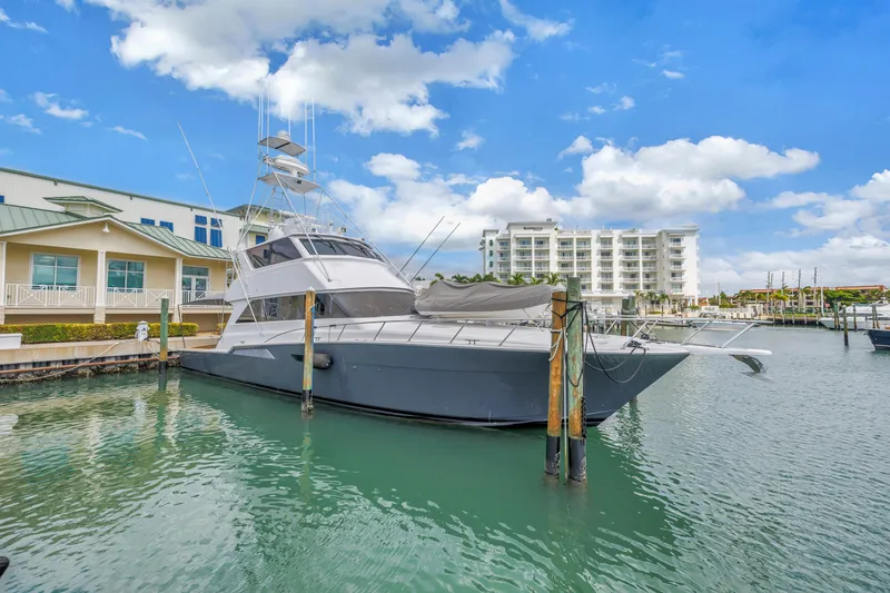 Slide: The Image of 1999 Viking 72 Enclosed Bridge yacht docked in marina with buildings in background. - 12