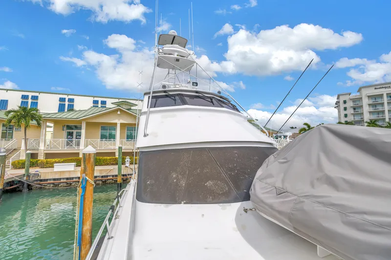 Slide: The Image of 1999 Viking 72 Enclosed Bridge yacht docked at marina under blue sky. - 14