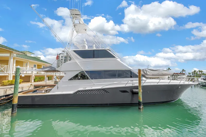 Slide: The Image of 1999 Viking 72 Enclosed Bridge yacht docked in a marina under a blue sky. - 2