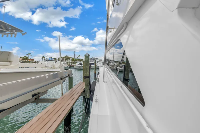 Slide: The Image of 1999 Viking 72 Enclosed Bridge yacht docked at marina under blue sky. - 21