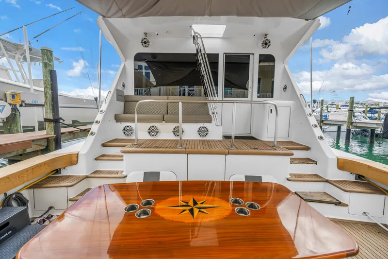 Slide: The Image of 1999 Viking 72 Enclosed Bridge yacht with elegant wooden deck and seating area. - 24