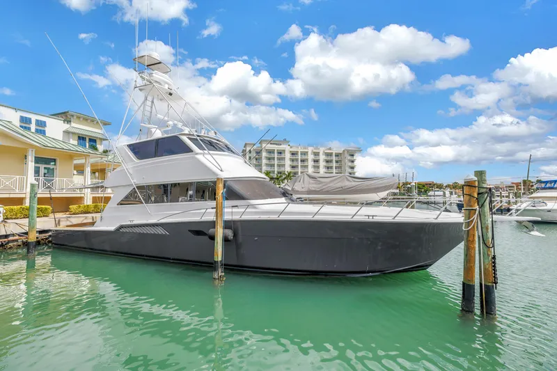 Slide: The Image of 1999 Viking 72 Enclosed Bridge yacht docked in a marina under a blue sky. - 3